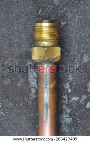Old copper water pipe on metal wall