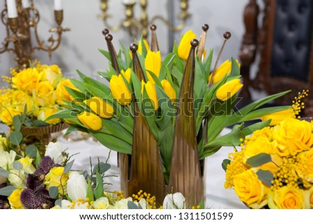 Crown shaped vase with yellow tulips, table set for an event party or wedding reception, luxury elegant table setting