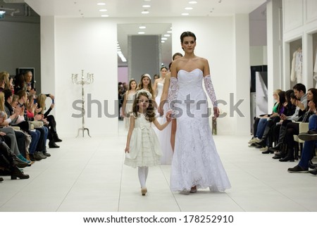 ZAGREB, CROATIA - FEBRUARY 22, 2014: Fashion model in wedding dress with little girl in bridesmaid dress on \'Wedding expo\' show