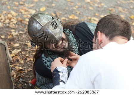 ZAGREB, CROATIA - OCTOBER 07, 2012: Squire helping injured knight to remove his helmet at \