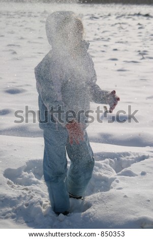 A girl on the snow throwing a snow ball