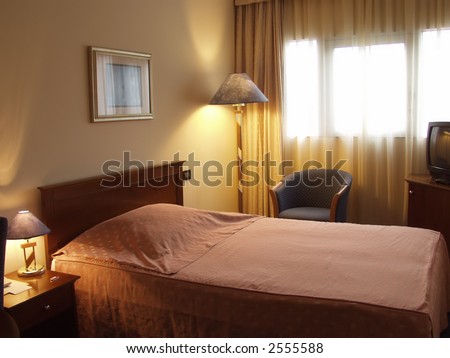Hotel room showing the bed night stand and lamp