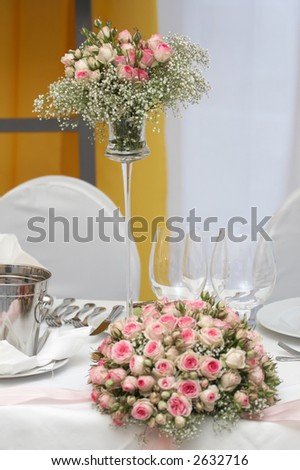 Table set for fine dining during a wedding event. Shallow depth of field, focus on the bouquet of flowers