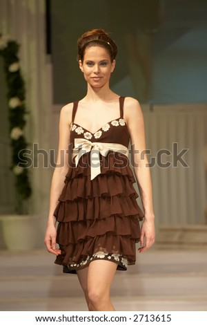 Model in sweet brown dress walking down the runway