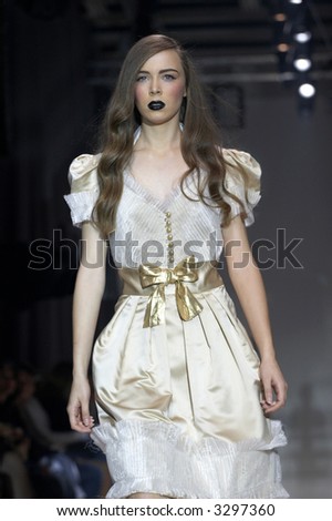 Fashion model in elegant white dress with golden belt