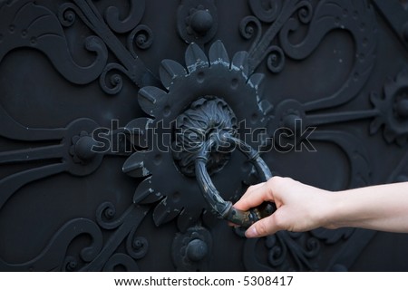 Female hand knocking on a closed door