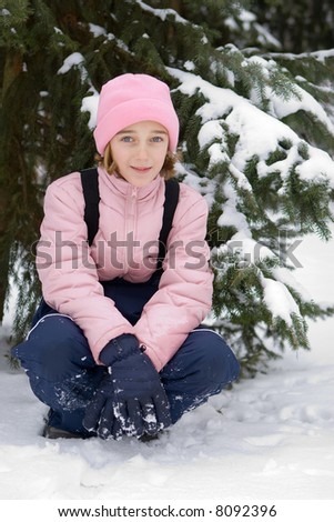 Girl in pink winter clothing on the snow