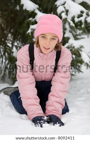 Girl in pink winter clothing on the snow