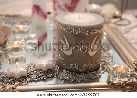 stock photo Big wedding candle decorated with white dows and rings