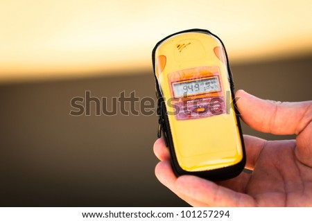 Geiger counter in hand with blurry background