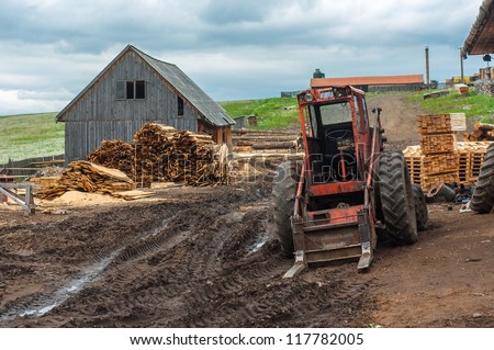 Wood industry outdoors with red tractor