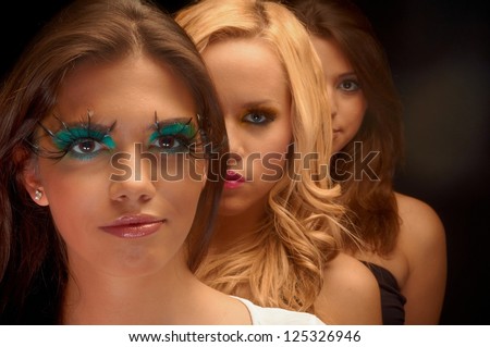 Some girls lined up in a studio with makeup
