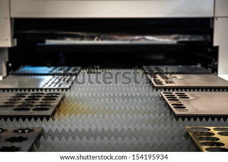Laser cutter cutting metal plates in a factory