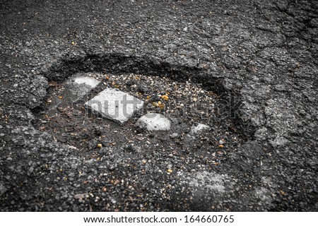 Tarmac road with big holes in Belgium