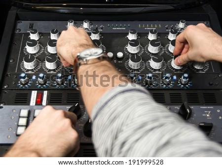 Hands on a sound mixer creating music