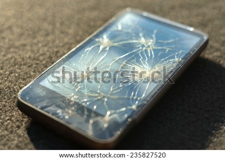Smartphone with broken screen on dark background
