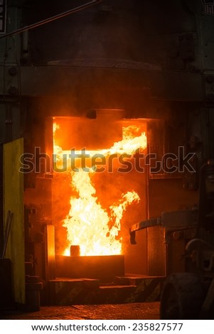 Hot iron in smeltery held by a worker