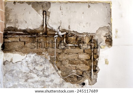 Damaged wall plumbing in a house closeup