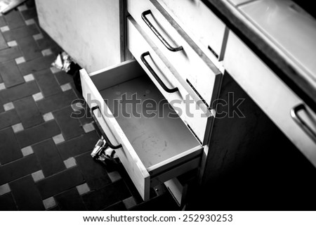 Cupboard with opened empty drawer closeup photo