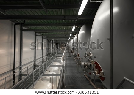 Large industrial white silos in modern factory interior