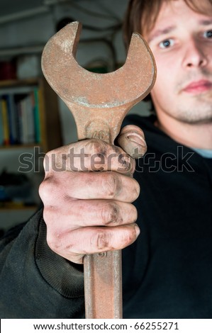 Worker holding large open-end wrench