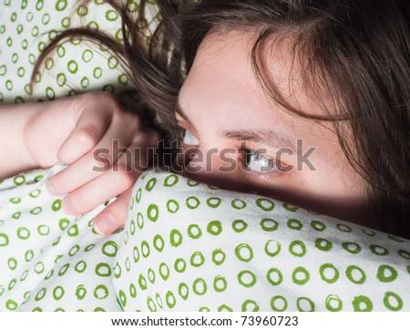 Girl scared of something under blanket