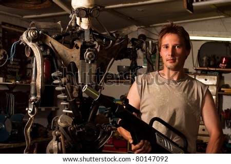 Young mechanic worker finished his robot