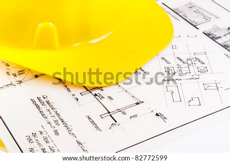 Construction plans with yellow helmet on it