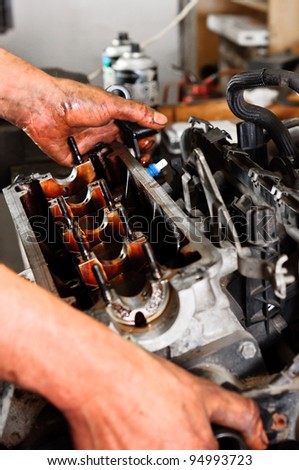 Hands of a worker repairing broken engine