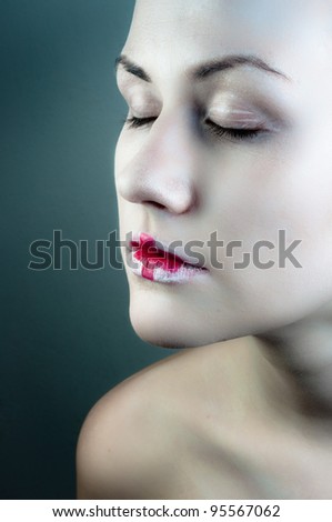 Conceptual makeup on a woman against dark background