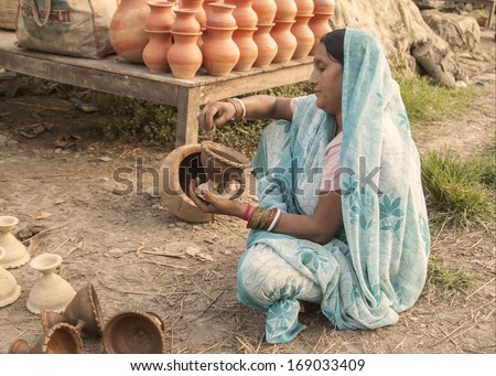 ASSAM, INDIA - AUGUST 13, 2006: A woman worker examines a clay pot on August 13, 2006, in Assam, India.  Women play an increasingly important role in the Indian economy.