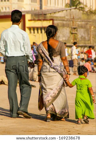 Varanasi, India - March 26, 2006: An Indian Family Strolls Along Juhu Beach In Mumbai. Juhu Beach Is A Popular Recreational Area For Mumbaikers.