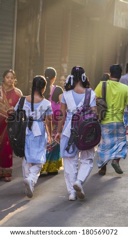 DHAKA, BANGLADESH - MARCH 8, 2014: School girls walk to school on a busy street in Old Dhaka.  Girls education has increased sharply in Bangladesh in recent years.