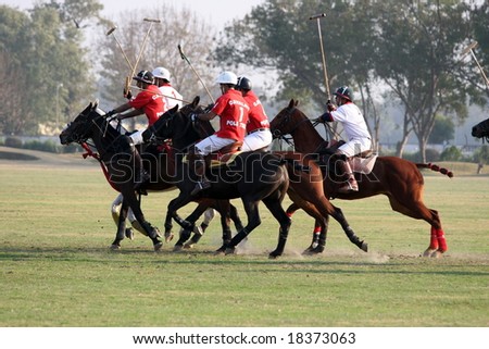 NEW DELHI - JANUARY 2008: A pack of polo players from the national team charge after the ball at a match in New Delhi\'s polo grounds in January 2008.