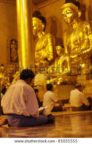 YANGON, MYANMAR (BURMA) - JUNE 25: Faithful Buddhists pray at the Shwedagon Pagoda on June 25, 2011 in Yangon, Myanmar, Burma.  The ruling junta tolerates religious expression.