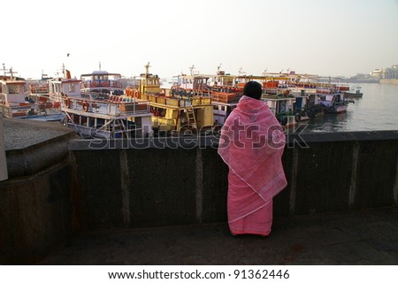 MUMBAI - FEBRUARY 9: An unidentified woman stares at tourist boats moored near Gateway of India on February 9, 2006.  This area was invaded by terrorists, who burned the nearby Taj Hotel, in 2009.