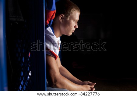A football player sits in his locker thinking about the game.