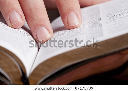 Close photo of man thumbing through the Bible. Macro.