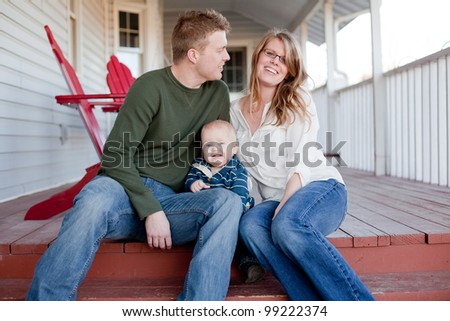 Young family laughing on the back porch.