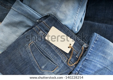 Pile of blue jeans with tag label.