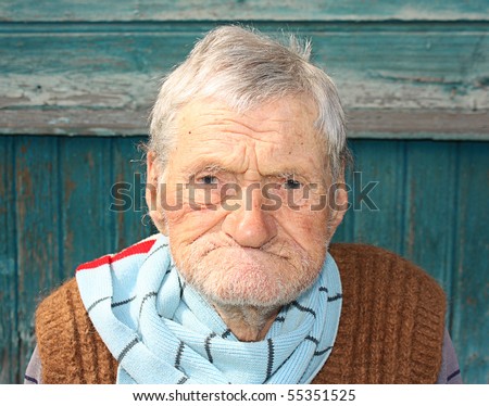 A portrait of a very old man, 96 years old near his house.