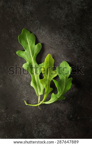 Rocket salad leaves shot from above on dark background