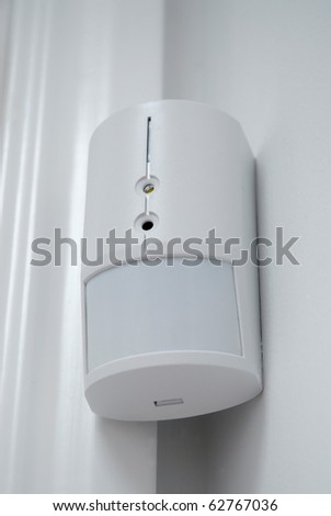 Closeup of a burglar alarm movement sensor mounted on a wall