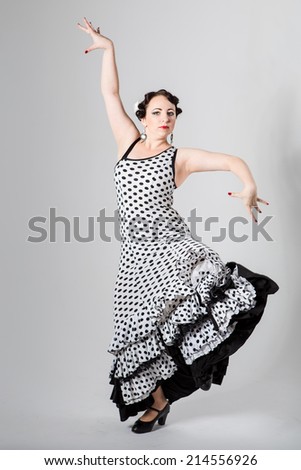 beautiful brunette female young beautiful brunette female spanish flamenco dancer in black and white flamenco dress dancing in studio on gray background