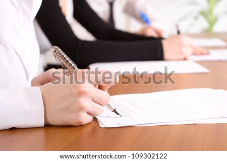 person\'s hand signing an important document