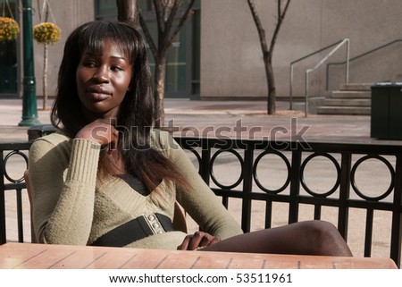 Attractive Young Woman Sits at Outdoor Patio Table