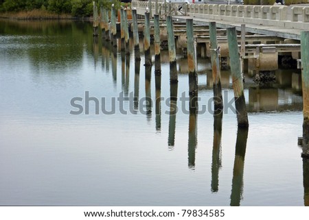 Pier pilings reflected in water in Florida