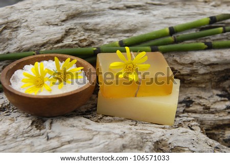 daisy flower with salt in bowl and soap on old wood texture