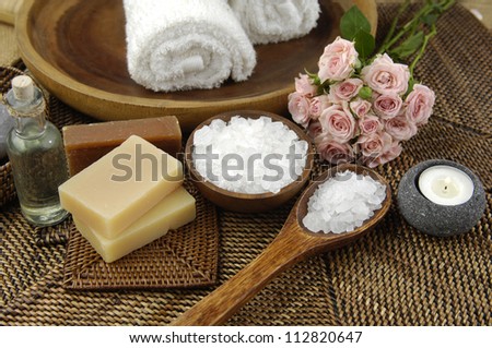 Spa Settings with bouquet of roses and salt in bowl , towel. Candle,soap on straw mat