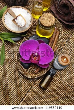 Spa wellness products Ã¢Â?Â?,massage oil ,stones, bowl of Spa salt ,leaf, candle on burlap mat